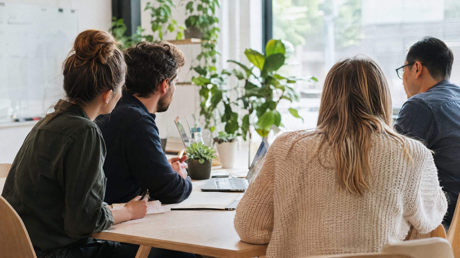 Equipo de una pequeña empresa reunido alrededor de una mesa