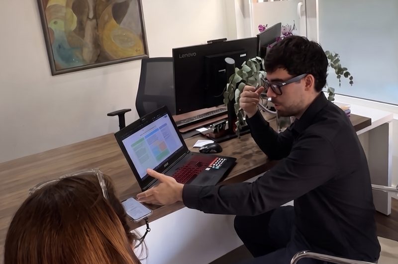 Un consultor de AITECA repasa en un portátil el plan de IA con una persona del equipo del cliente, en su oficina